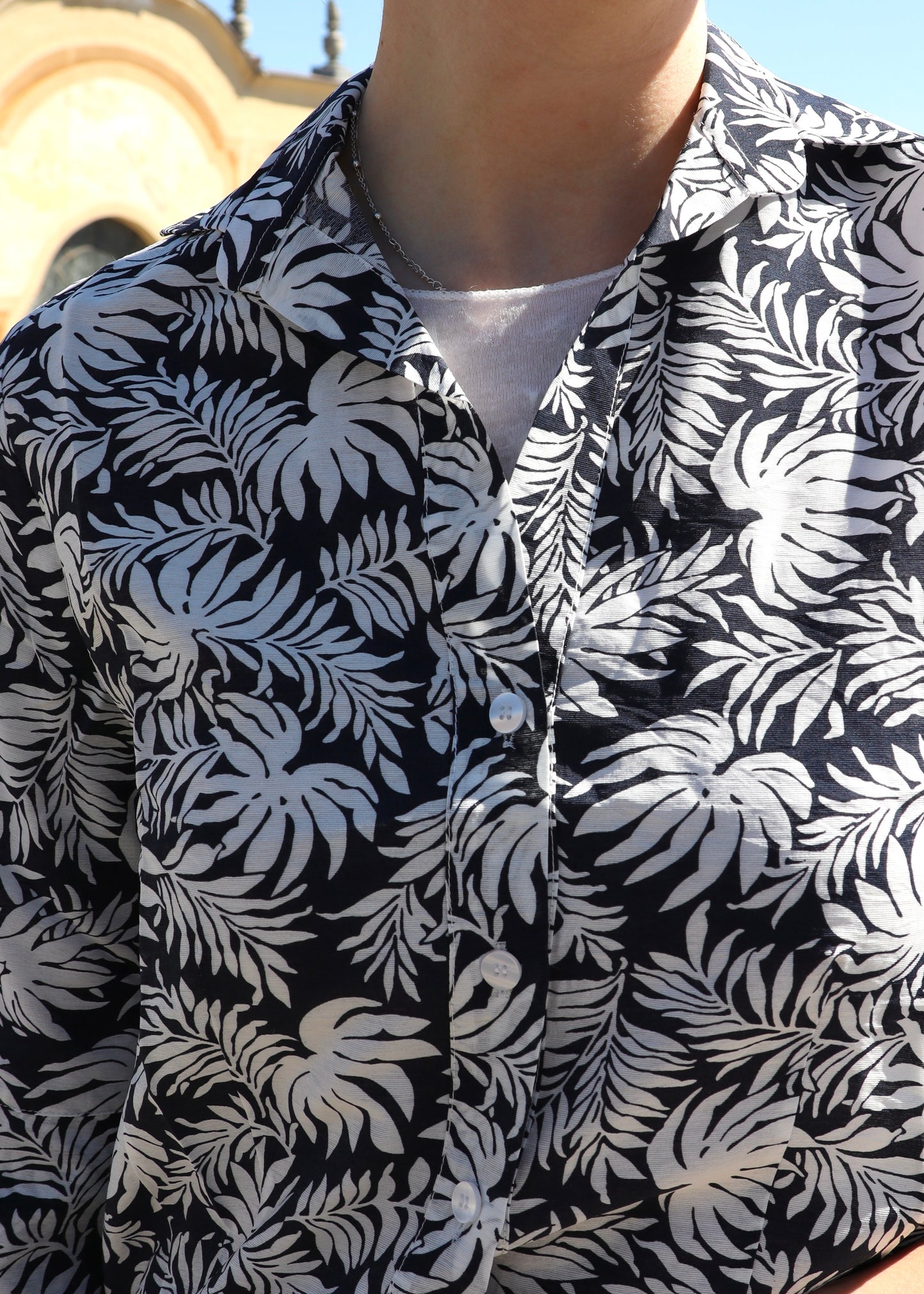 Camicione in cotone con fantasia a foglie nero e bianco, taglio ampio e leggero, vestibilità comoda e versatile, made in Italy, ideale per look casual ed eleganti.