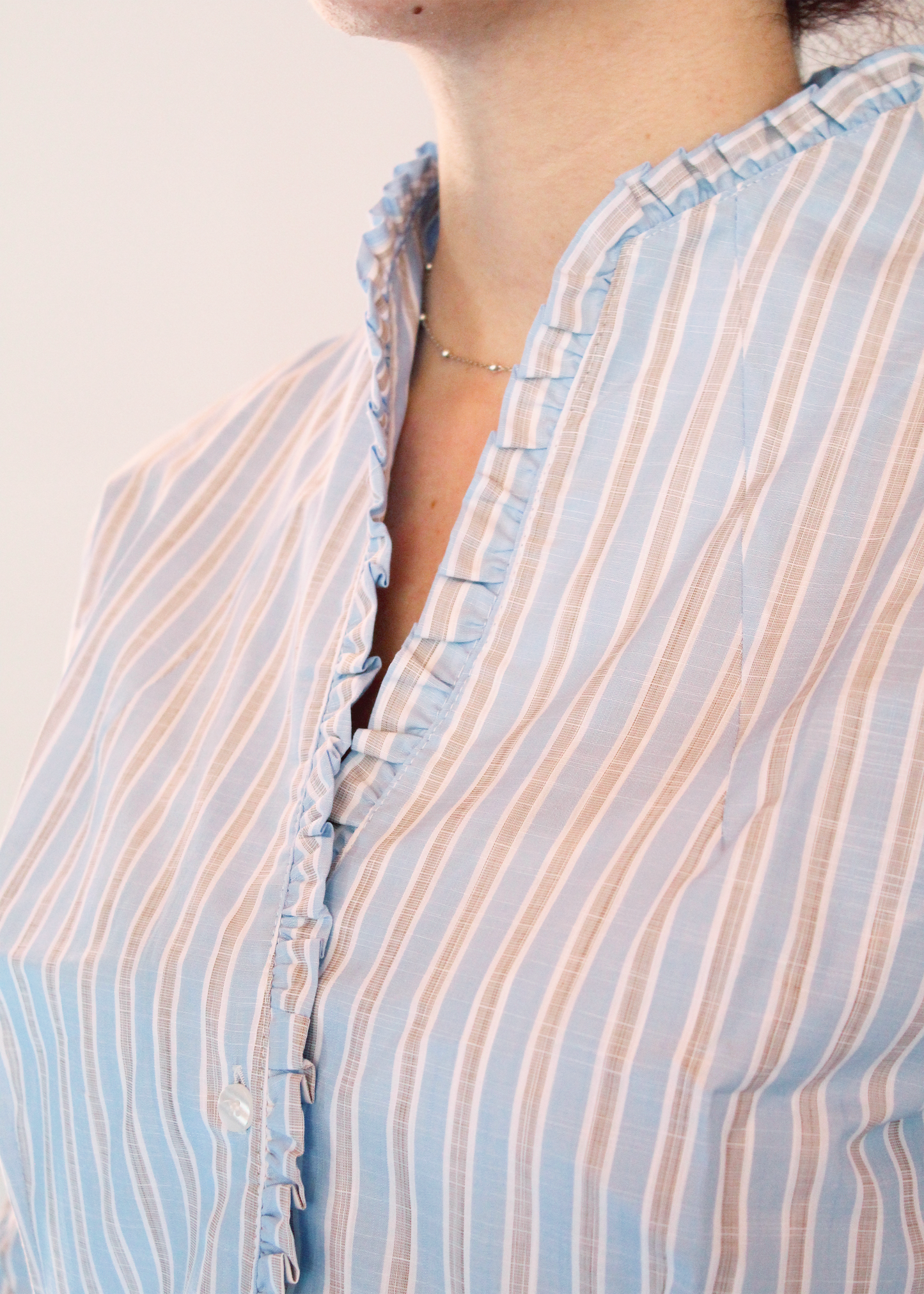 Camicia rigata con scollo a v e Rouches è artigianale in 100% cotone con righe larghe azzurre, marroni e bianche. Design elegante con scollo a V e rouches femminili. Made in Italy.