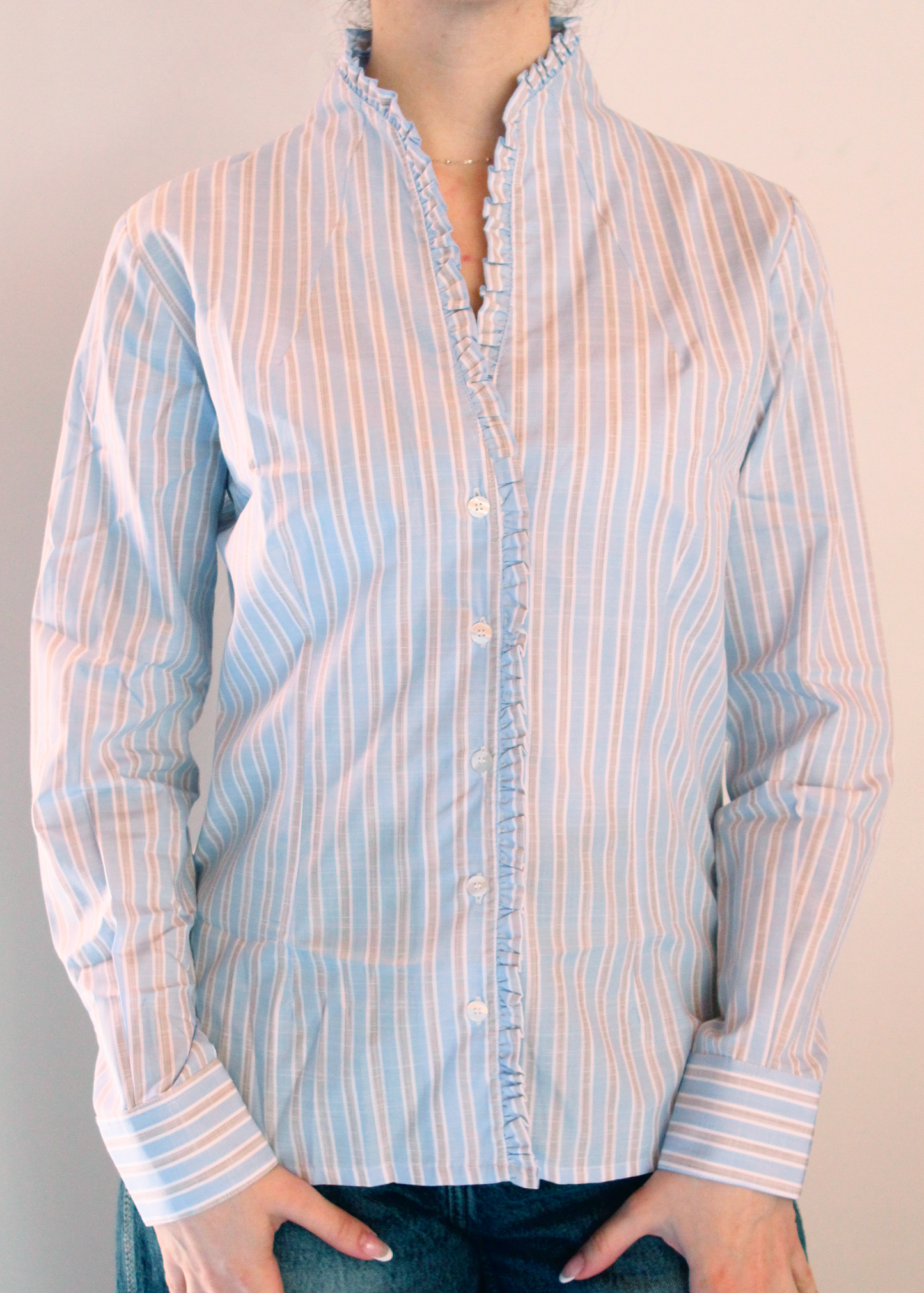 Camicia rigata con scollo a v e Rouches è artigianale in 100% cotone con righe larghe azzurre, marroni e bianche. Design elegante con scollo a V e rouches femminili. Made in Italy.