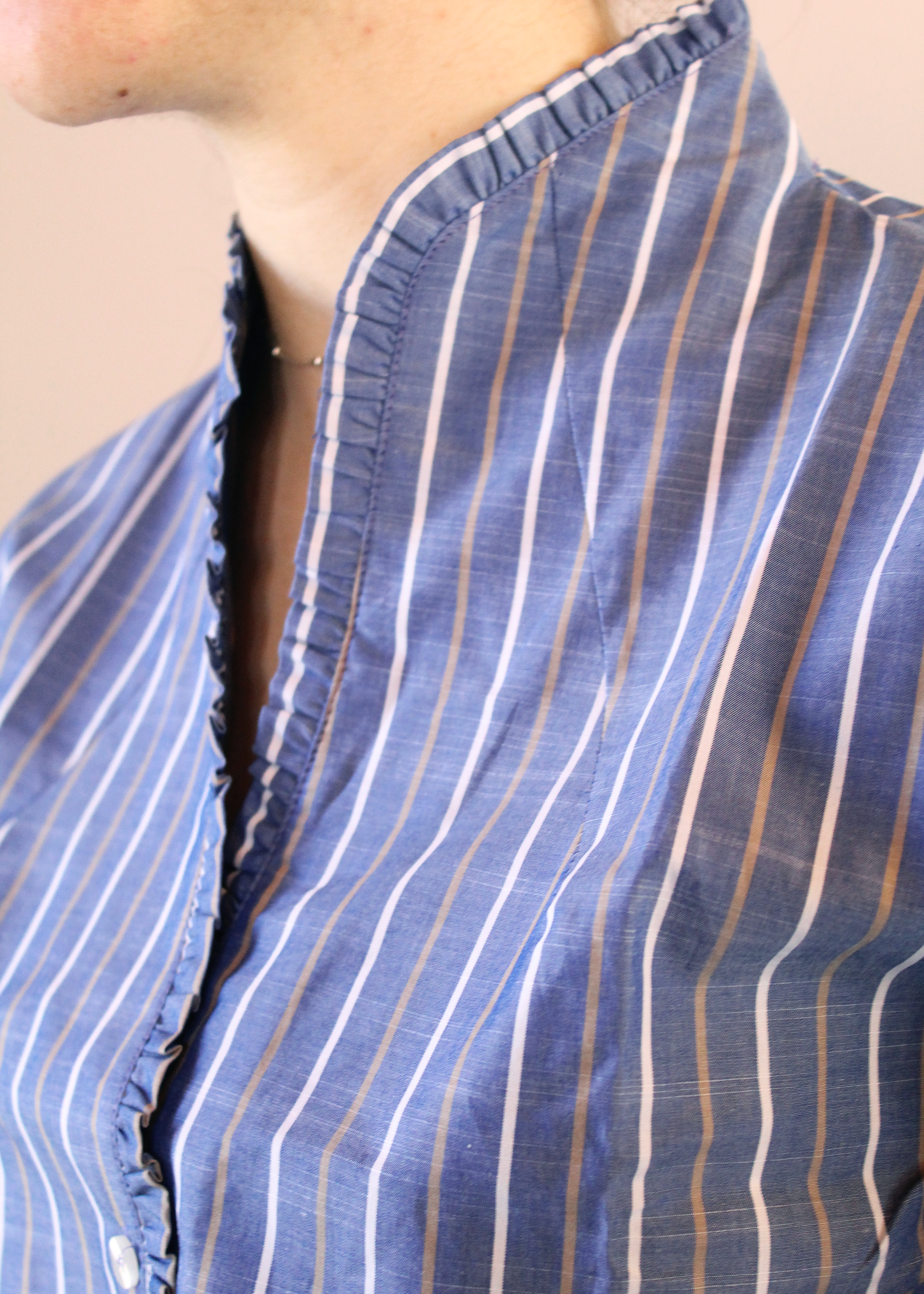 Camicia artigianale in 100% cotone color jeans con righe bianche e marroni. Design versatile con scollo a V e rouches femminili. Realizzata dalla maglieria artigianale di Genova di Strike Inside. Made in Italy.