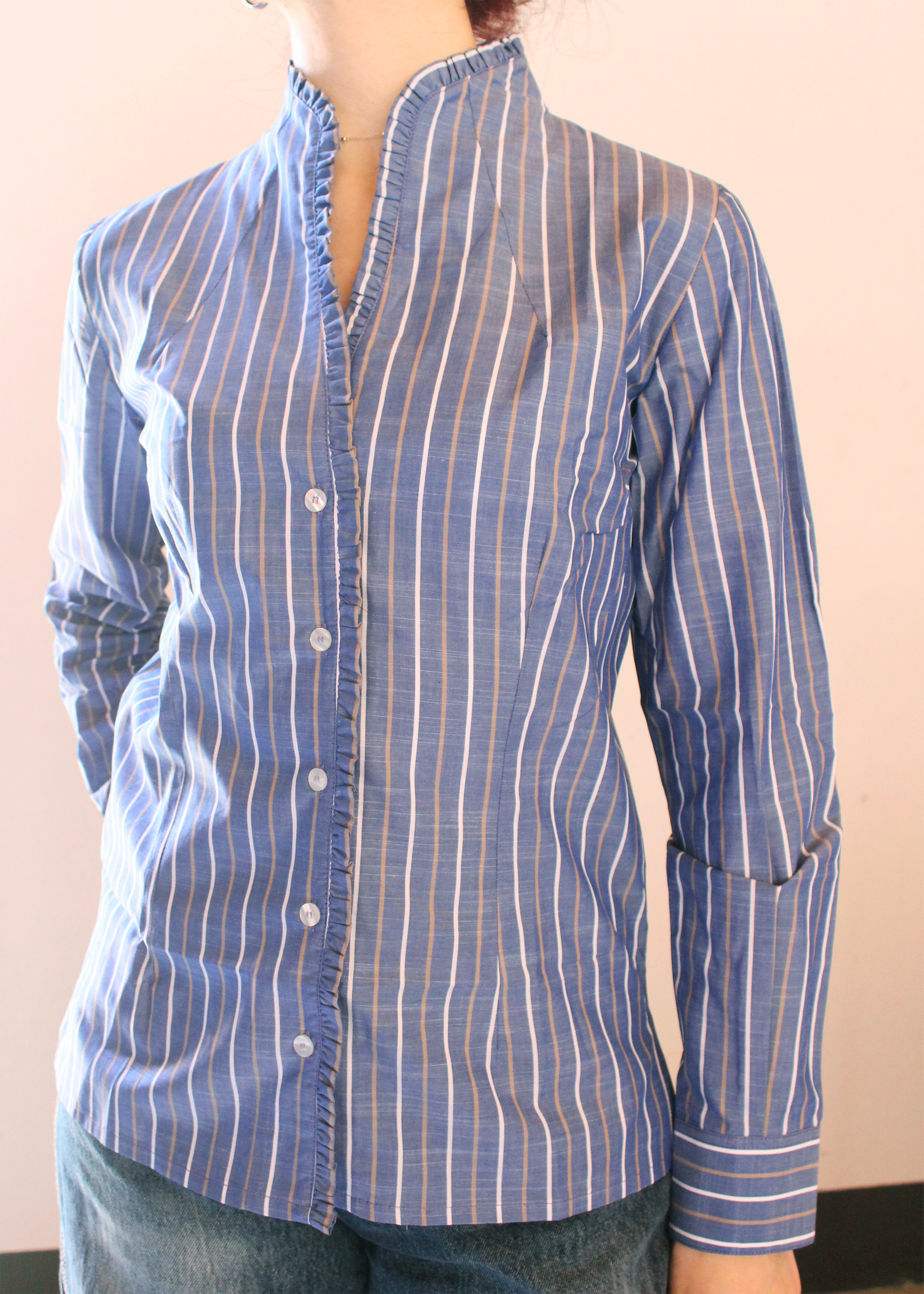 Camicia artigianale in 100% cotone color jeans con righe bianche e marroni. Design versatile con scollo a V e rouches femminili. Realizzata dalla maglieria artigianale di Genova di Strike Inside. Made in Italy.