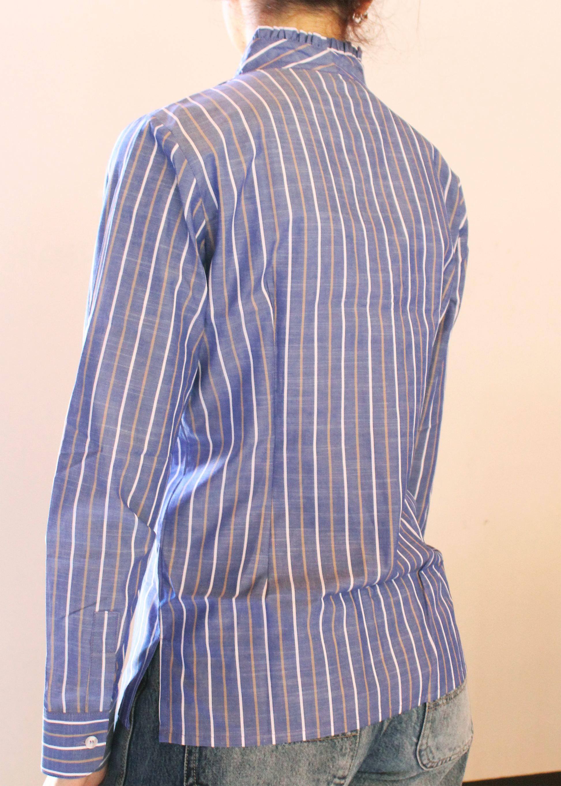 Camicia artigianale in 100% cotone color jeans con righe bianche e marroni. Design versatile con scollo a V e rouches femminili. Realizzata dalla maglieria artigianale di Genova di Strike Inside. Made in Italy.