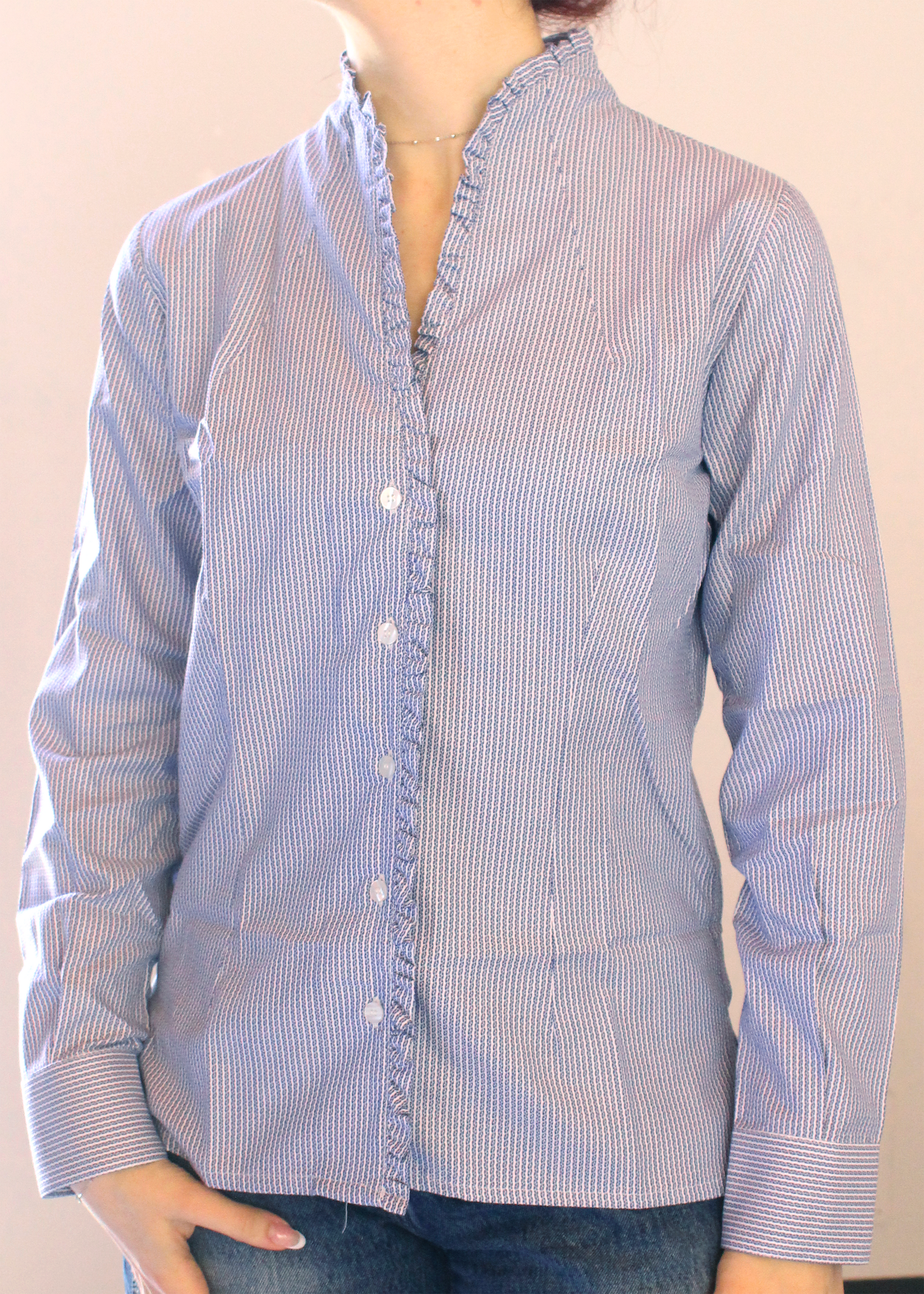 Camicia artigianale in 100% cotone con raffinato pattern a righe bianche e blu. Il design è arricchito da un motivo discreto che dona profondità e carattere alle righe blu. Scollo a V con eleganti rouches per un tocco femminile e sofisticato. Realizzata con cura dalla maglieria artigianale di Genova di Strike Inside. Made in Italy.
