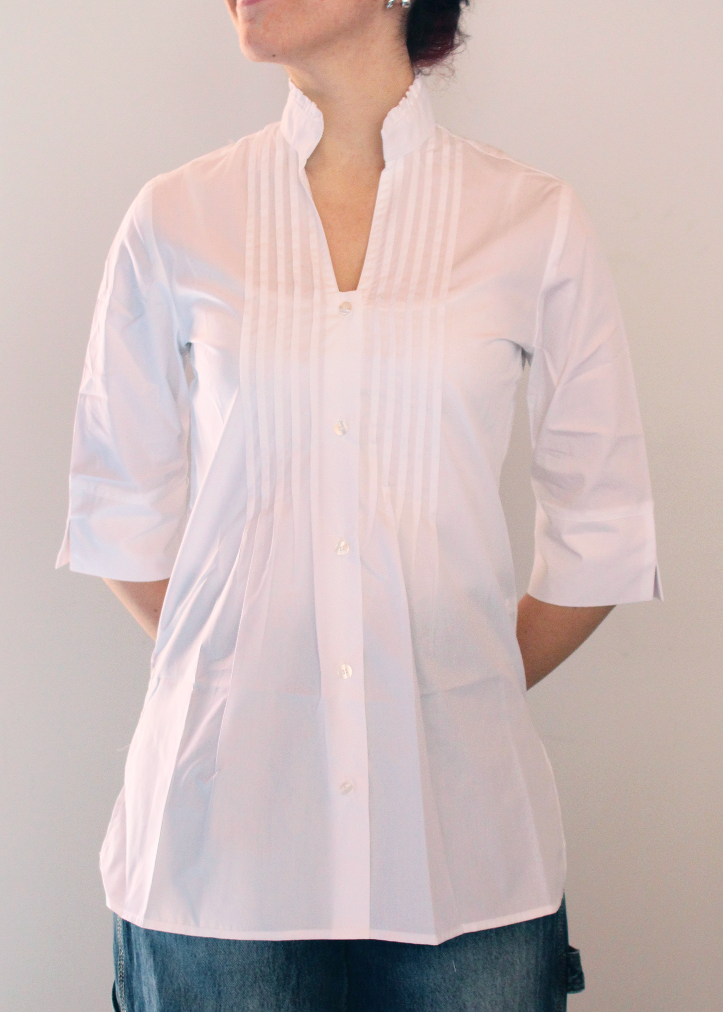 Camicia artigianale in 100% cotone, leggera e traspirante, disponibile in tinta unita bianco. Design sofisticato con collo alla coreana e dettagli plissettati sul petto. Maniche a 3/4, perfetta per le mezze stagioni. Realizzata con cura dalla maglieria artigianale di Genova di Strike Inside. Made in Italy.