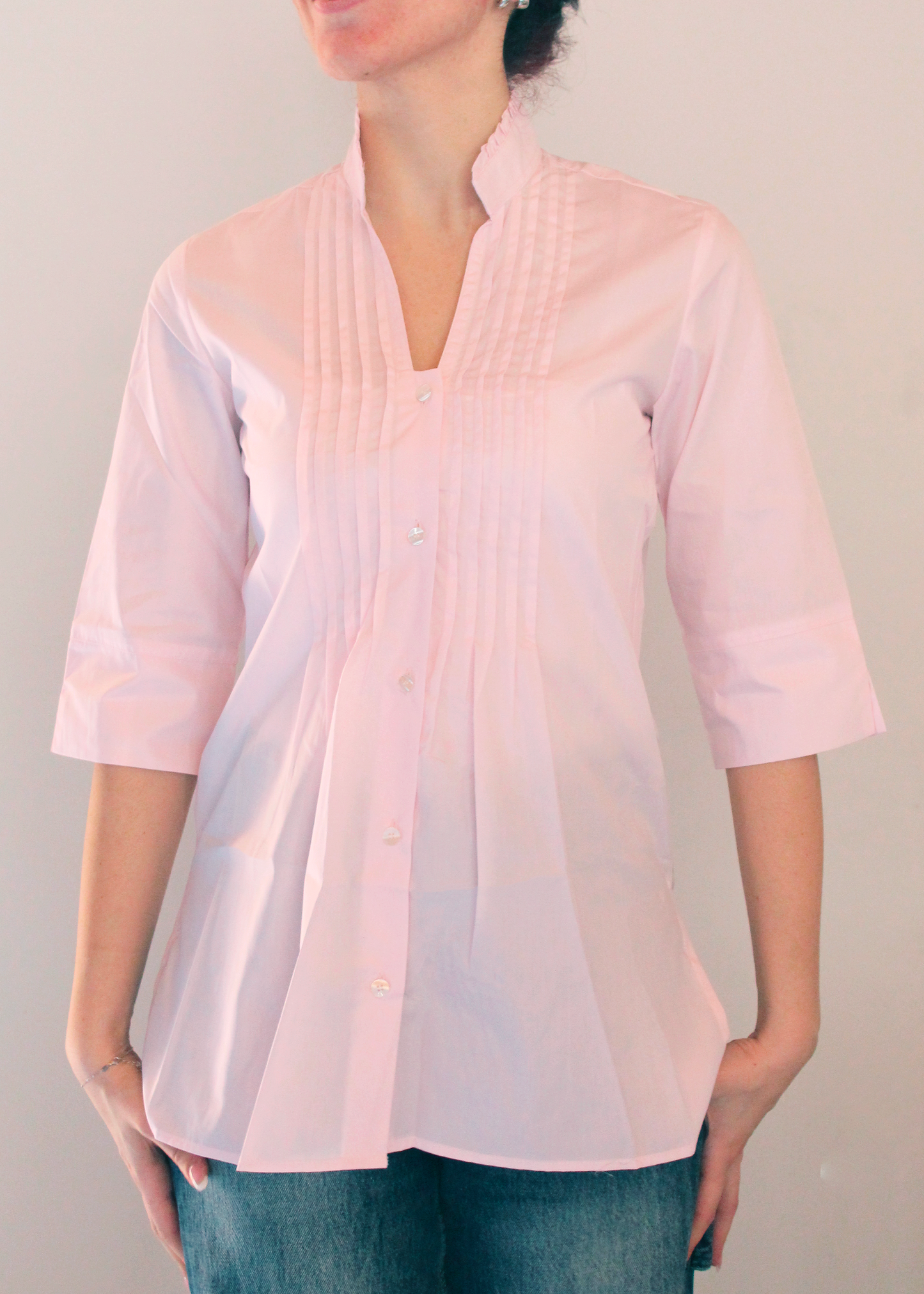Camicia artigianale in 100% cotone, leggera e traspirante, disponibile in tinta unita rosa. Design sofisticato con collo alla coreana e dettagli plissettati sul petto. Maniche a 3/4, perfetta per le mezze stagioni. Realizzata con cura dalla maglieria artigianale di Genova di Strike Inside. Made in Italy.