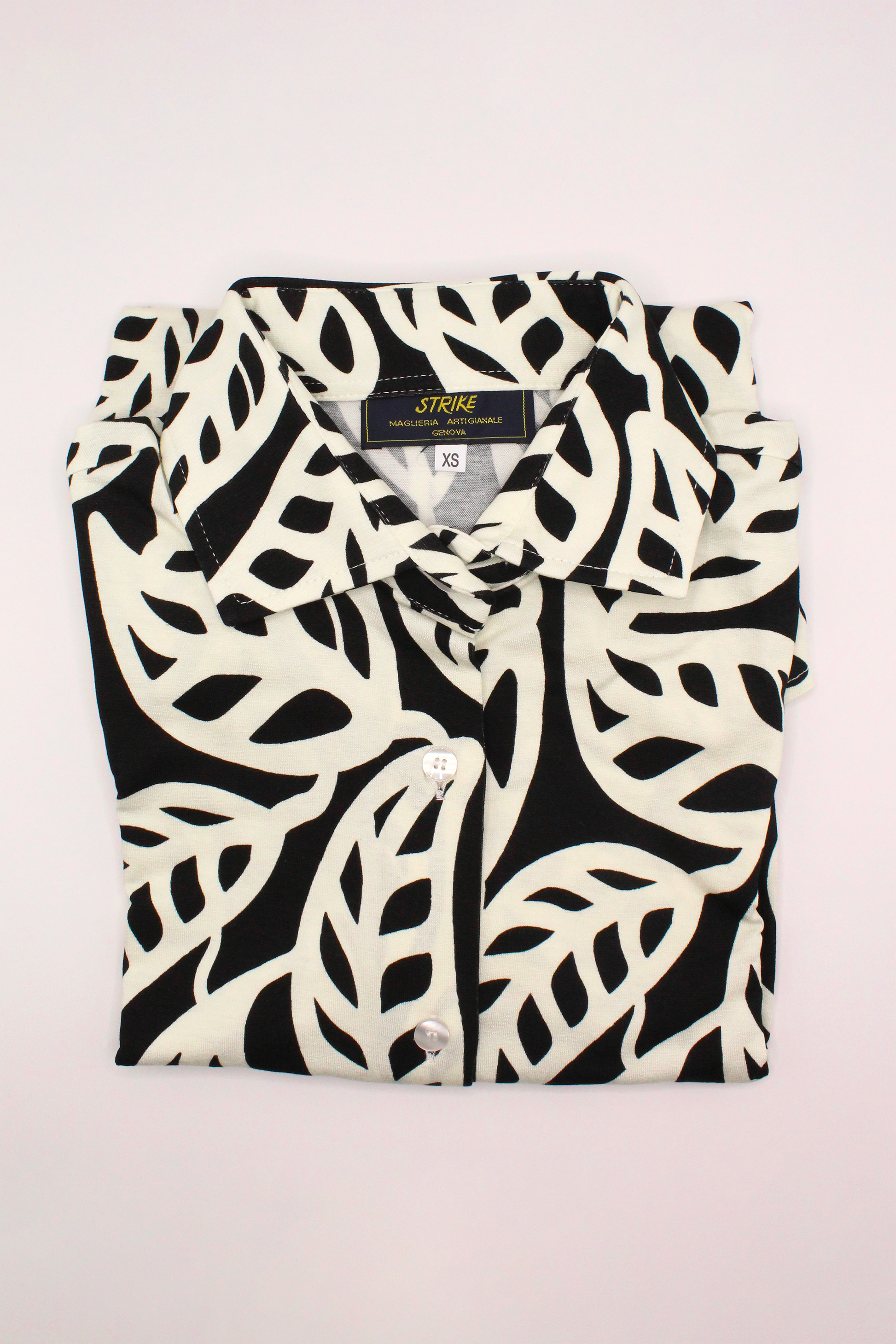La camicia donna in viscosa elasticizzata offre una vestibilità comoda e segue armoniosamente le forme del corpo. Il taglio classico e il tessuto leggero la rendono perfetta per un look casual chic o per outfit più sofisticati. La sua fantasia floreale in bianco e nero dona un tocco di eleganza senza tempo, ideale per ogni occasione. Un capo di abbigliamento artigianale, firmato Strike Inside, realizzato a Genova, 100% Made in Italy, con materiali di alta qualità