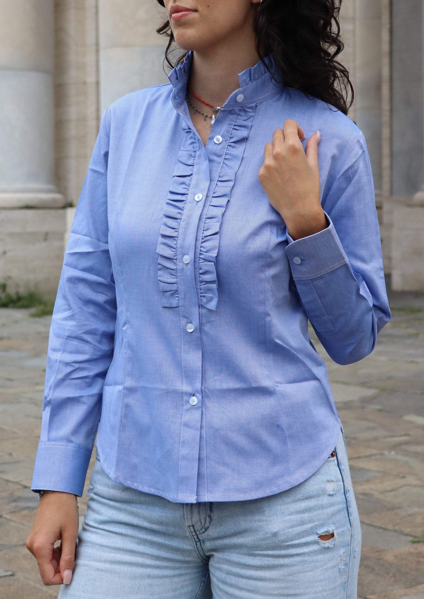 Camicia da donna in cotone con rouches decorative sul petto e sul colletto. Un modello femminile e raffinato, caratterizzato da dettagli romantici che donano volume e movimento. Ideale per un look elegante e distintivo, adatto sia a contesti casual chic che a occasioni formali.