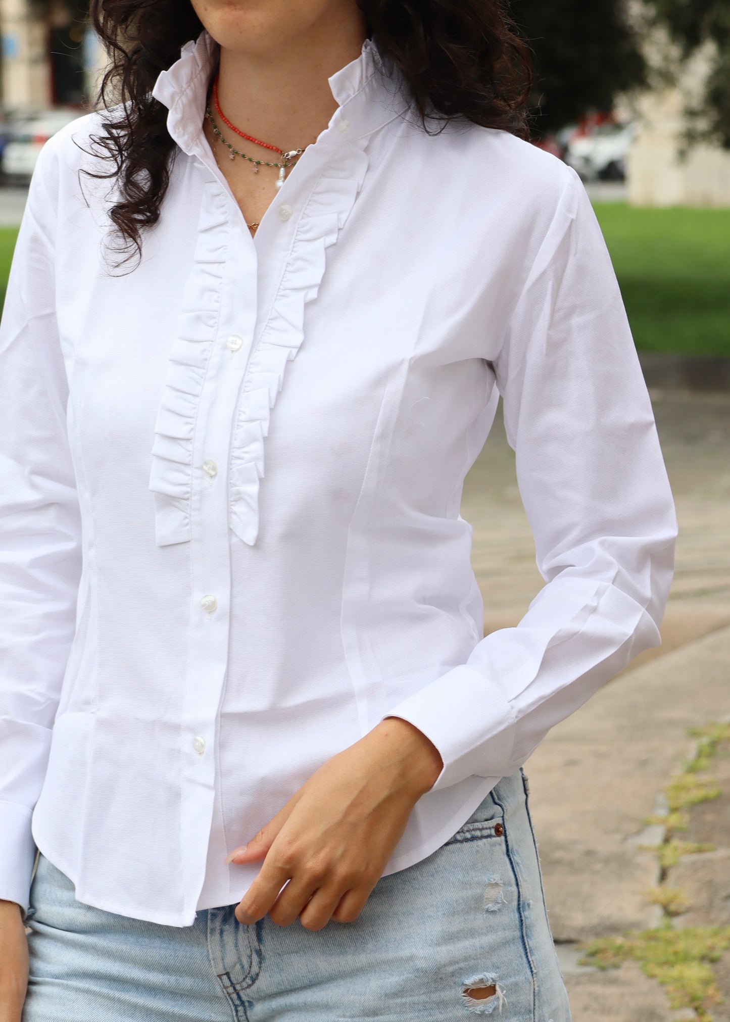 Camicia da donna in cotone con rouches decorative sul petto e sul colletto. Un modello femminile e raffinato, caratterizzato da dettagli romantici che donano volume e movimento. Ideale per un look elegante e distintivo, adatto sia a contesti casual chic che a occasioni formali.
