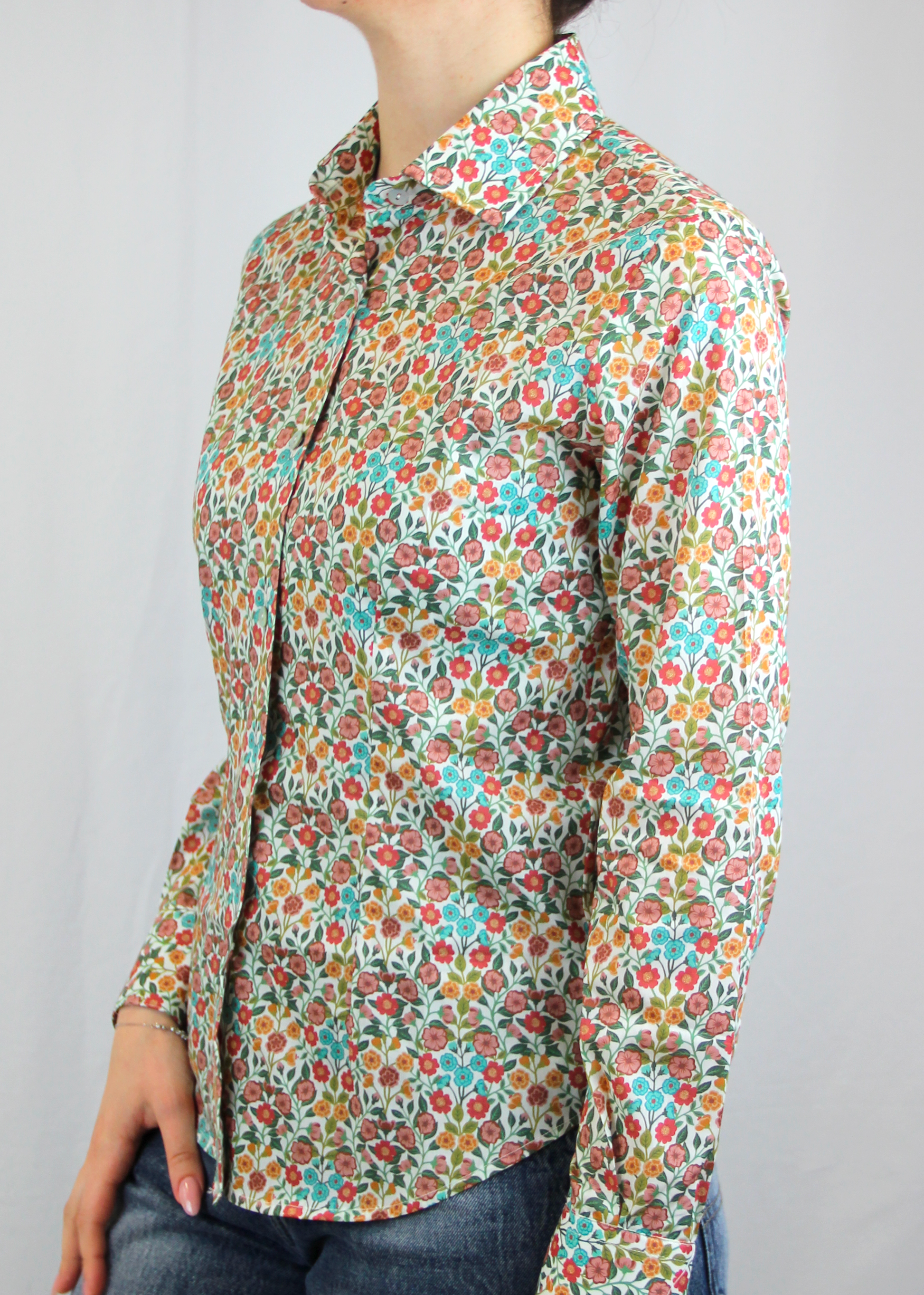 La camicia in cotone Liberty è un capo essenziale dal design senza tempo, realizzato artigianalmente in Italia in 100% cotone di alta qualità. La sua fantasia millefiori in rosa antico e azzurro, con toni autunnali, aggiunge un tocco delicato e raffinato al capo. Il taglio classico la rende versatile, perfetta sia per outfit casual che per occasioni più formali, assicurando comfort, traspirabilità e una vestibilità impeccabile. Un prodotto esclusivo, Made in Italy, che unisce eleganza e tradizione.