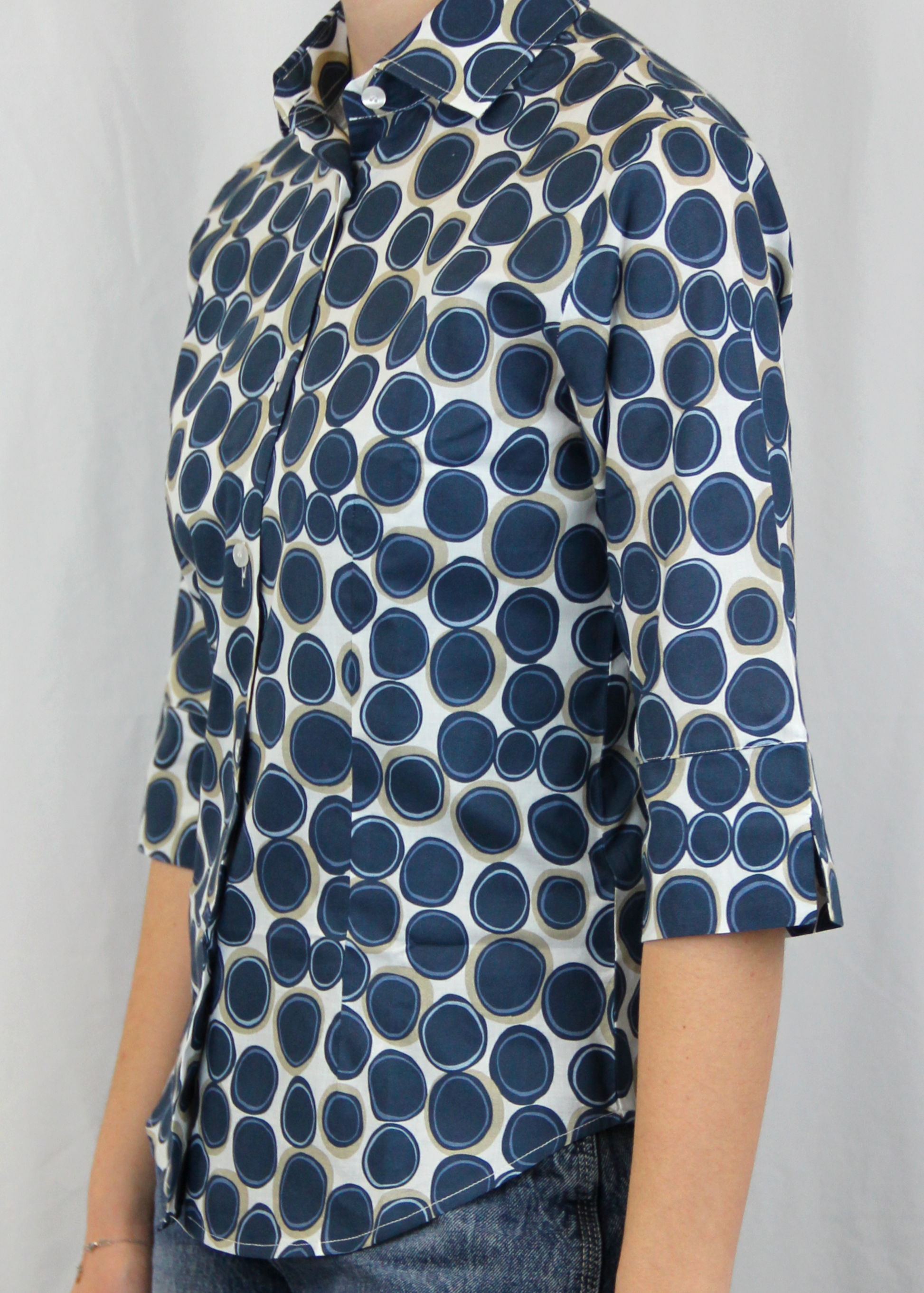 La camicia con manica a 3/4 è realizzata artigianalmente in 100% cotone leggero di alta qualità. Il taglio classico è arricchito dalla manica a 3/4, che conferisce un'eleganza informale, rendendo il capo perfetto per tutte le stagioni. La fantasia con cerchi, disponibile in verde e blu, aggiunge un tocco di originalità senza perdere la sobrietà. Un'ottima scelta per chi cerca uno stile curato e distintivo, ogni giorno. Made in Italy, per un look sofisticato e contemporaneo.