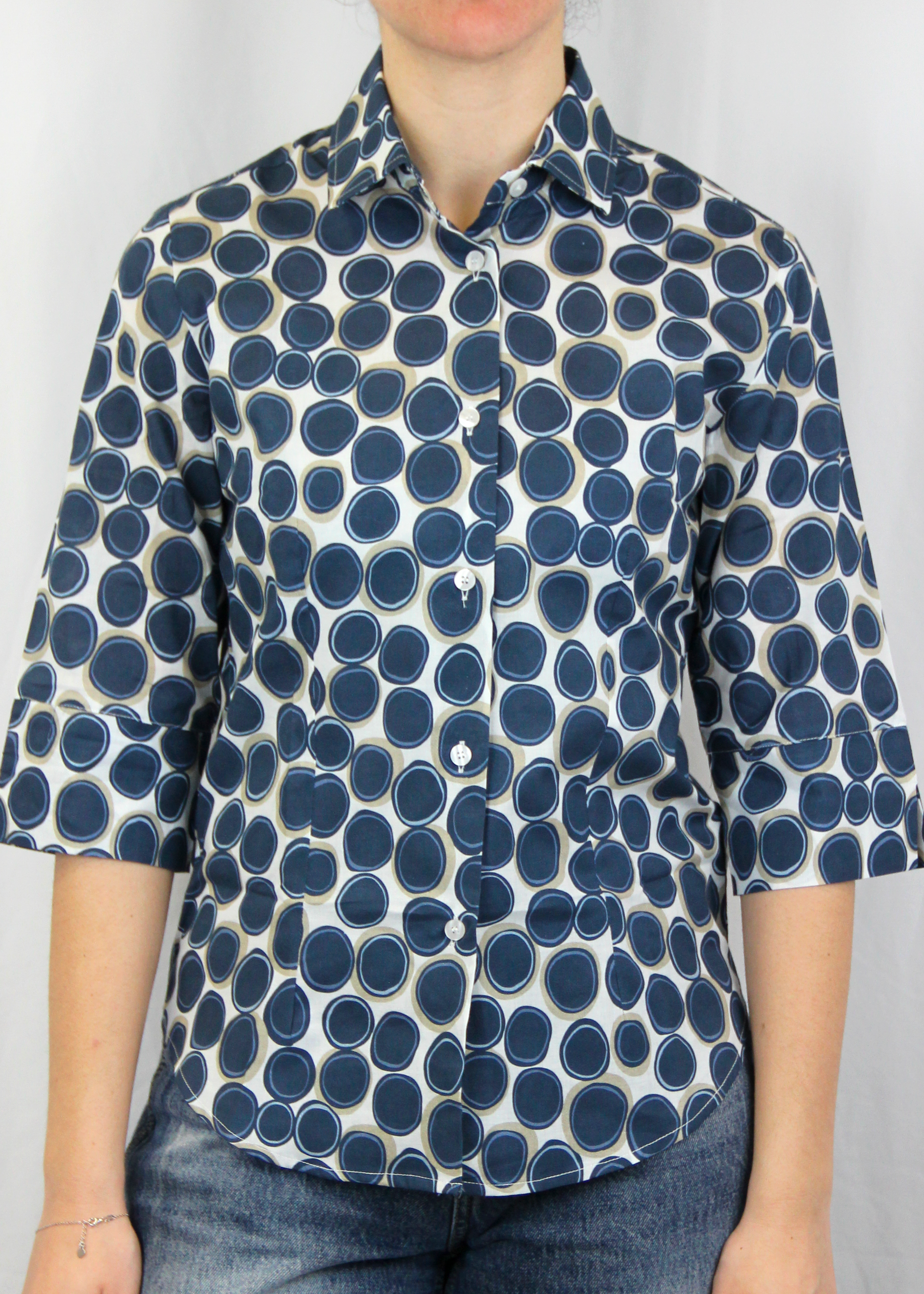 La camicia con manica a 3/4 è realizzata artigianalmente in 100% cotone leggero di alta qualità. Il taglio classico è arricchito dalla manica a 3/4, che conferisce un'eleganza informale, rendendo il capo perfetto per tutte le stagioni. La fantasia con cerchi, disponibile in verde e blu, aggiunge un tocco di originalità senza perdere la sobrietà. Un'ottima scelta per chi cerca uno stile curato e distintivo, ogni giorno. Made in Italy, per un look sofisticato e contemporaneo.