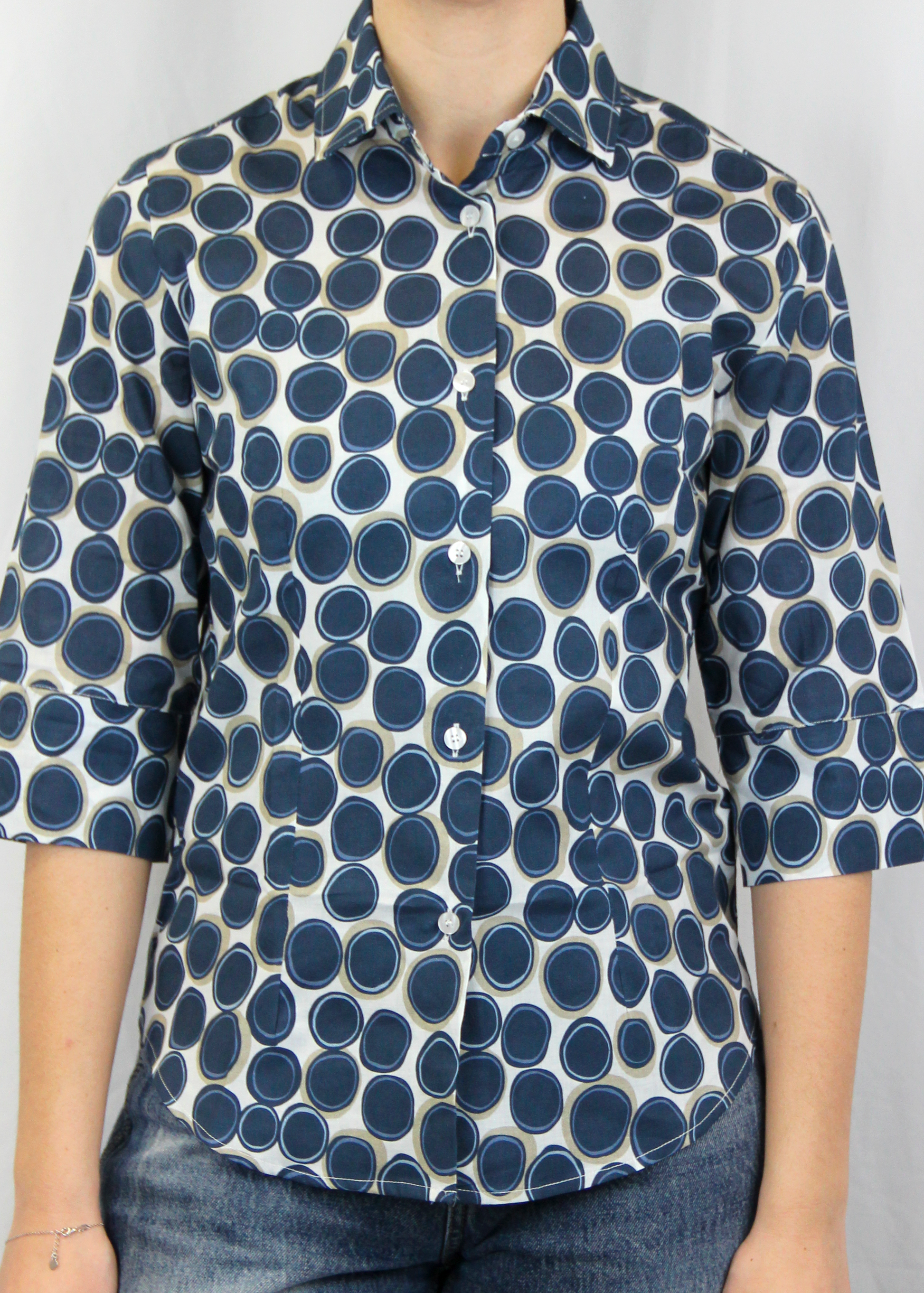 La camicia con manica a 3/4 è realizzata artigianalmente in 100% cotone leggero di alta qualità. Il taglio classico è arricchito dalla manica a 3/4, che conferisce un'eleganza informale, rendendo il capo perfetto per tutte le stagioni. La fantasia con cerchi, disponibile in verde e blu, aggiunge un tocco di originalità senza perdere la sobrietà. Un'ottima scelta per chi cerca uno stile curato e distintivo, ogni giorno. Made in Italy, per un look sofisticato e contemporaneo.